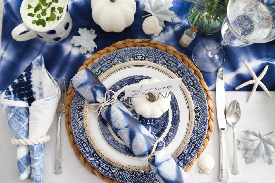 Beautiful blue coastal place setting with starfish place card and rolled napkin on blue plate