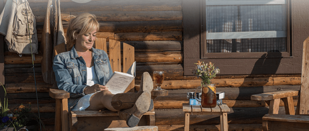 Dude ranches in Wyoming: Woman sitting on porch relaxing at Triangle X Ranch