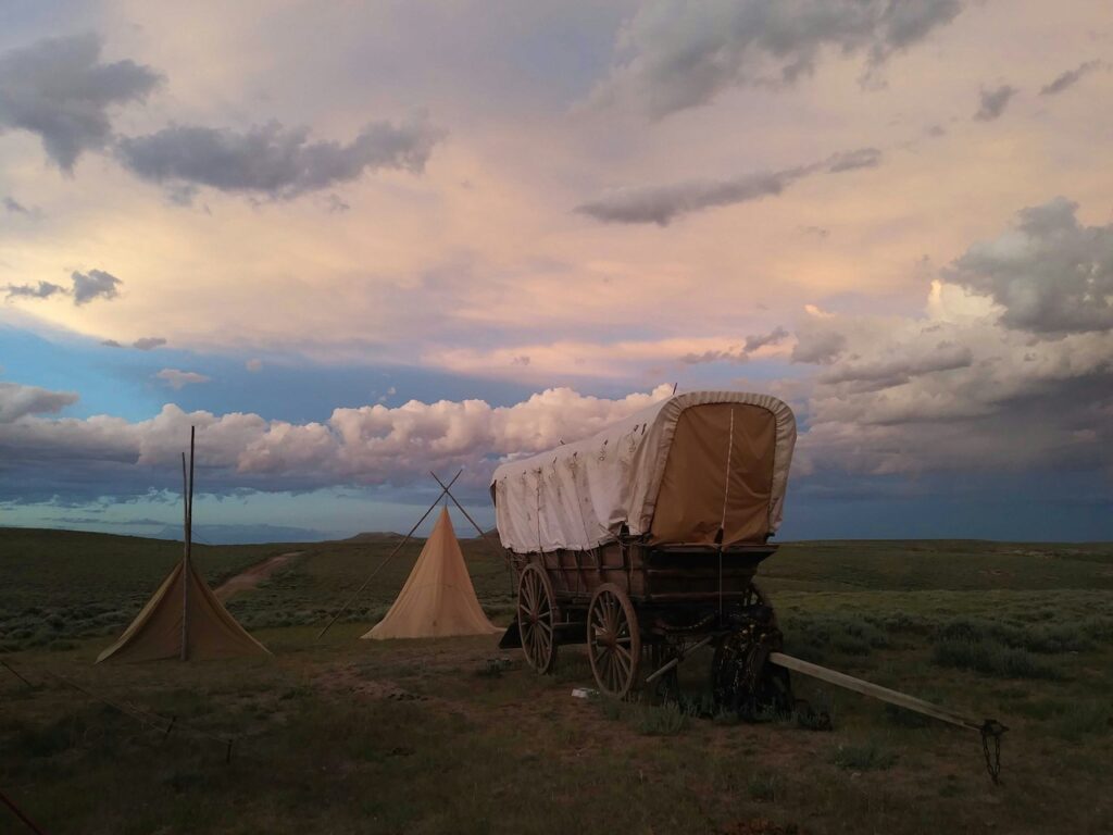 Dude ranches in Wyoming covered wagon at sunset