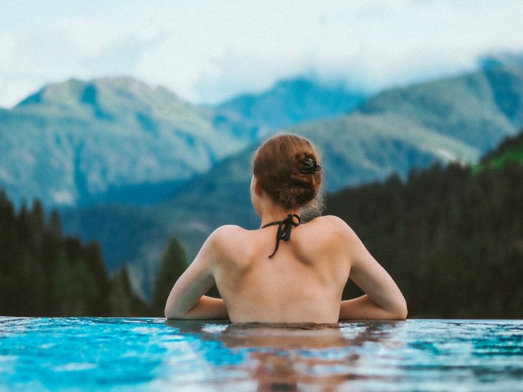 Woman in hot tub looking out over mountains